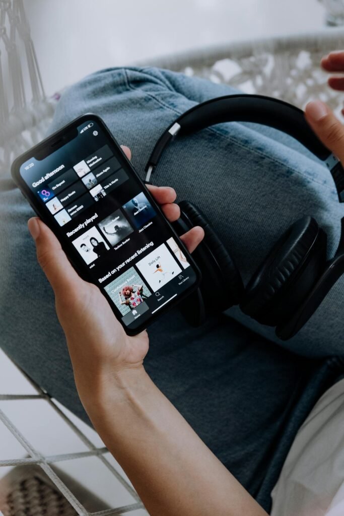 Une personne se détendant sur un canapé, plongée dans un livre audio captivant , écouter des livres audio